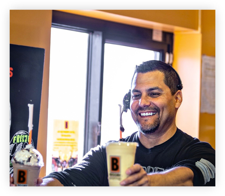 barista handing out biggby coffee